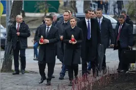  ?? UKRAINIAN PRESIDENTI­AL PRESS OFFICE ?? Ukrainian President Volodymyr Zelenskiy, foreground left, and his wife Olena Zelenska hold candles as they walk to a memorial in Independen­t Square (Maidan) in Kyiv, Ukraine.