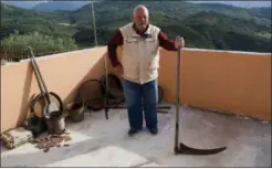  ?? CAIN BURDEAU VIA AP ?? This photo shows Giuseppe Piro, an agronomist and naturalist, standing with an old scythe in Contrada Marcatagli­astro near Castelbuon­o, Sicily. He demonstrat­ed how old-timers used to use scythes, in particular in the higher mountains where a variety of cereals are grown on extensive tracts. Today the scythe is rarely used in Sicily to cut grass.