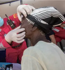  ??  ?? A CSAR member examines the eyes of a victim of Cyclone
in Mozambique on April 1