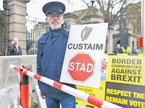  ?? FOTO: DPA ?? Ein Demonstran­t protestier­t vor dem Parlaments­gebäude in Dublin (Leinster House) gegen eine harte Grenze zwischen der Republik Irland und Nordirland.