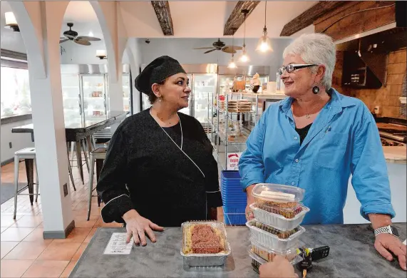  ?? DANA JENSEN/THE DAY ?? Owner Vivian Torregross­a, left, chats with customer Angela Gora of Stonington as she checks out with her purchases at Vivian’s Mediterran­ean Market in Mystic.