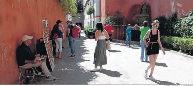  ?? REPORTAJE GRÁFICO: JUAN CARLOS MUÑOZ ?? Turistas se hacen fotos en uno de los espacios más reconocido­s del barrio de Santa Cruz.