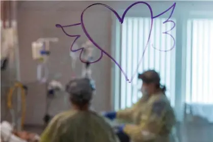  ?? Photograph: Nic Coury/AFP/Getty Images ?? A heart with wings is drawn on the window as nurses care for a Covid-19 patient inside the ICU at Adventist Health in Sonora, California, last month.