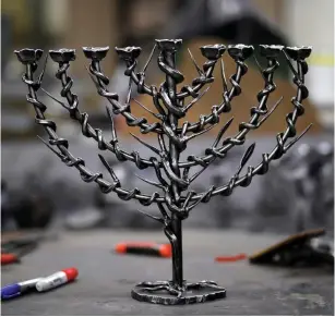  ?? (Reuters) ?? ‘ALL RABBINIC commentari­es agree that the light of the Hanukkah candles may not be used for our own benefit – we are not even permitted to use the light from the flames to read in a dimly lit room.’