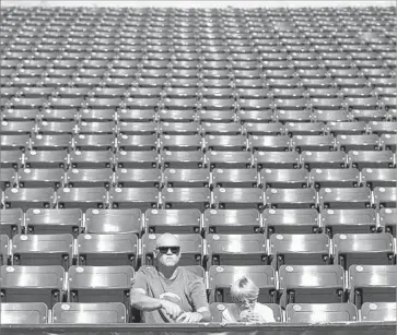  ?? Robert Gauthier Los Angeles Times ?? WITH PLENTY of elbow room around them on the east side of StubHub Center, Malibu resident Jason Maynard and son Xander take in workout. The Chargers invited season-ticket holders and those on a waiting list.