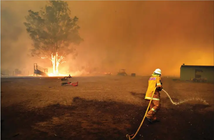  ??  ?? Brandvaesn­et i New South Wales forsøger at beskytte en ejendom i naerheden af byen Tahmoor. Blot een ejendom af mange, der risikerer at bliver fortaeret af flammerne. Foto: Dean Lewins