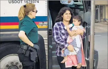  ?? Loren Elliott AFP/Getty Images ?? A WOMAN and child are released at a bus depot in McAllen, Texas, this week and will remain free pending an immigratio­n hearing. Other migrants have been charged with illegal entry and separated from their children.