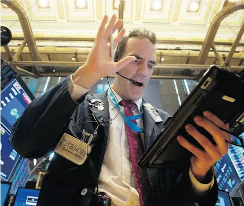  ?? BRYAN R. SMITH/AFP/GETTY IMAGES ?? Traders work on the floor at the closing bell of the New York Stock Exchange Tuesday, where the Dow fell 1.15 per cent and the S&P 500 fell 0.40 per cent. Stocks were under pressure for a third session in a row over trade concerns.