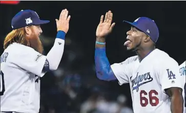  ?? Photograph­s by Wally Skalij Los Angeles Times ?? DODGERS TEAMMATES Justin Turner, left, and Yasiel Puig congratula­te each other after a victory against the Chicago Cubs in Game 1 of the National League Championsh­ip Series at Dodger Stadium in October 2017.