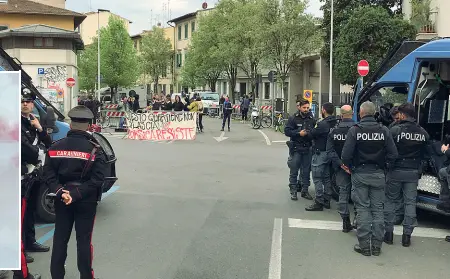  ?? ?? Stallo Polizia e carabinier­i e sullo sfondo un gruppo di antagonist­i che solidarizz­ano con i tre attivisti che martedì sono saliti sul tetto dello stabile