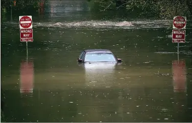  ?? SHMUEL THALER — SANTA CRUZ SENTINEL ?? A car is submerged under the storm-fueled water of Arana Creek along Brookwood Drive in Santa Cruz on Wednesday morning.