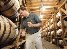  ?? ASSOCIATED PRESS FILE PHOTO ?? Jeff Arnett, the master distiller at the Jack Daniel Distillery in Lynchburg, Tenn., drills a hole in a barrel of whiskey in one of the aging houses at the distillery in 2009.