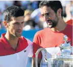  ??  ?? TROPHY JOY Cilic, right, consoles Djokovic