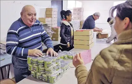  ?? MIGUEL MEDINA / AFP ?? Voluntario­s de la oenegé Les Restos du Coeur reparten alimentos en una ciudad al norte de París