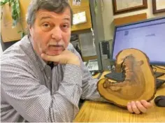  ?? USA TODAY NETWORK-TENNESSEE ?? University of Tennessee professor of geography Henri Grissino-Mayer, who studies tree rings, displays a segment from a tree in the Great Smoky Mountains National Park that reveals multiple fires through its growth.