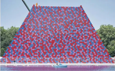  ?? AFP ?? Workers are dwarfed by ‘The Mastaba’, an installati­on by Bulgarian artist Christo made up of more than 7,000 stacked barrels