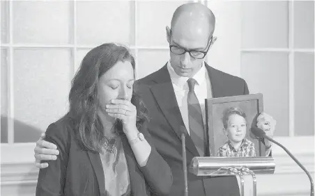  ??  ?? Carly and John Sutherland address a news conference in Halifax last week. John holds a photo of nine-year-old Callum.