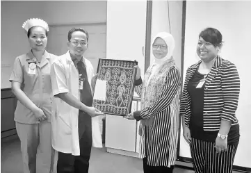  ??  ?? Kapit Health Clinic director Dr Jusoh Awang Senik presents a memento to Dr Safurah. At right is Kapit health officer Dr Deborra Ngadan.