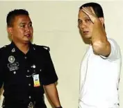  ??  ?? Claiming trial: Chin being led away by a police officer from the courtroom in Kuala Lumpur yesterday.