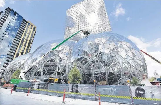 ?? Elaine Thompson Associated Press ?? CONSTRUCTI­ON continued in this April photo on expansion of the Amazon campus in Seattle. Amazon said recently it will build another headquarte­rs elsewhere.