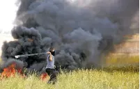  ?? ADEL HANA/THE ASSOCIATED PRESS ?? A Palestinia­n protester slings stones toward Israeli soldiers Friday during clashes with Israeli troops along the Gaza Strip border with Israel.