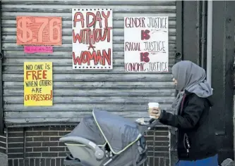  ?? MATT ROURKE/THE ASSOCIATED PRESS ?? A woman pushes a stroller past a Philadelph­ia, Penn., restaurant shuttered in solidarity with A Day Without a Woman on Wednesday. Organizers of January’s Women’s March called on women to stay home from work and not spend money in stores or online to...