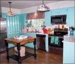  ??  ?? Cheerful painted cabinets and colorful light   xtures add to the charm of the spacious kitchen.