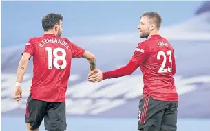  ?? REUTERS ?? Manchester United’s Luke Shaw, right, celebrates with Bruno Fernandes after scoring his team’s second goal against Manchester City.