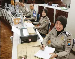  ?? GUSLAN GUMILANG/JAWA POS ?? PEMANTAU PELANGGARA­N: Operator e-TLE di RTMC Polda Jatim bertugas menganalis­is rekaman CCTV yang terpasang di jalan protokol Surabaya kemarin.