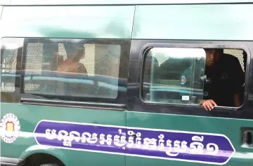  ??  ?? Uon Chhin and Yeang Sothearin sit inside a police vehicle as they arrive for a bail hearing at the Appeal Court in Phnom Penh, Cambodia. — Reuters photo