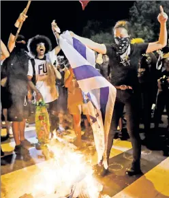  ??  ?? Fueling the flames of hate: Protesters burn an Israeli flag while chanting “Intifada” at the Democratic National Convention Tuesday night.