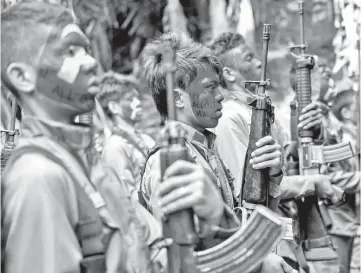  ??  ?? File photo of guerrillas of the New People’s Army (NPA) standing in formation in the Sierra Madre mountain range, located east of Manila. — AFP photo