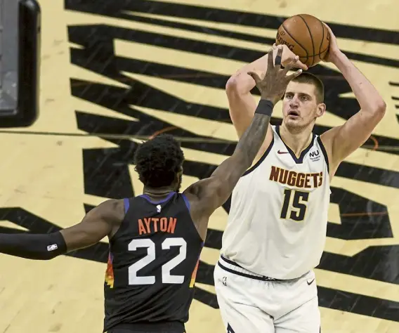  ?? AAron Ontiveroz, The Denver Post ?? Denver’s Nikola Jokic (15) shoots over Phoenix’s Deandre Ayton (22) during the second quarter of Monday night’s playoff game in Phoenix.