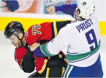  ?? JEFF MCINTOSH/ THE CANADIAN PRESS ?? The Flames' Blair Riley fights with Vancouver Canucks' Brandon Prust during NHL pre- season hockey action in Calgary on Friday night.