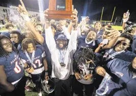  ?? A. WALLACE For the Miami Herald ?? Chaminade-Madonna coach Dameon Jones and his players celebrate after defeating Clearwater Central Catholic 48-14 to claim the Class 1M state championsh­ip.