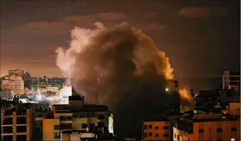  ?? Mohammed Abed / Getty Images ?? Smoke billows after an Israeli airstrike struck the Andalus Tower in Gaza city, controlled by the Palestinia­n Hamas movement, on Saturday. Israel pummelled the Gaza Strip with air strikes, killing 10 members of an extended family and demolishin­g a building housing internatio­nal media outlets.