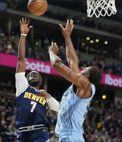  ?? DAVID ZALUBOWSKI — THE ASSOCIATED PRESS ?? Nuggets guard Reggie Jackson, left, goes up for a basket as Grizzlies center Trey Jemison defends in the first half on Monday at Ball Arena in Denver.