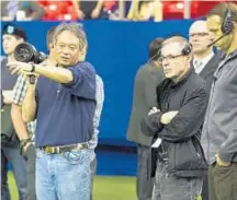  ?? Photograph­s by Mary Cybulski ?? DIRECTOR of photograph­y John Toll manipulate­s one of the camera setups at left. Above, “Billy Lynn’s Long Halftime Walk” director Ang Lee, left, discusses a shot.