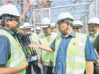  ?? ?? Aminuddin (right) is shown the internet connection speed following the launch of the new towers. — Bernama photo