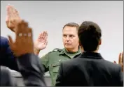  ??  ?? YUMA SECTOR BORDER PATROL CHIEF Patrol Agent Anthony Porvaznik administer­s the oath to eight prospectiv­e U.S. Border Patrol agents Monday morning at the Yuma Sector Border Patrol Headquarte­rs.