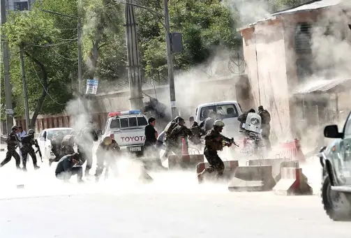  ?? MASSOUD HOSSAINI/AP ?? APARAT YANG SEMBURAT: Polisi dan tentara berlarian saat bom kedua meledak di Kabul kemarin. Pelaku bom bunuh diri diduga menyasar jurnalis yang sedang meliput.