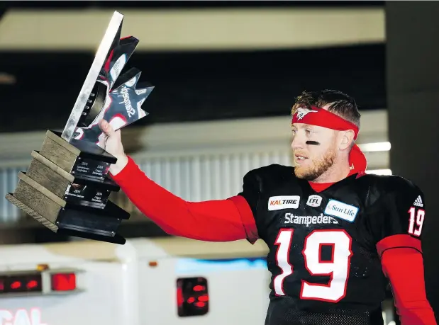  ?? THE CANADIAN PRESS ?? Calgary quarterbac­k Bo Levi Mitchell displays the West Division trophy following the Stampeders’ workmanlik­e 22-14 victory over the Blue Bombers Sunday at McMahon Stadium. The Stamps are off to their third Grey Cup in three years. They lost the first two.