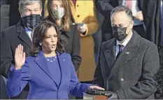  ?? Brendan Smialowski / Getty Images ?? Kamala Harris, flanked by her husband Doug Emhoff, is sworn in as vice president by Supreme Court Justice Sonia Sotomayor Wednesday at the Capitol in Washington.