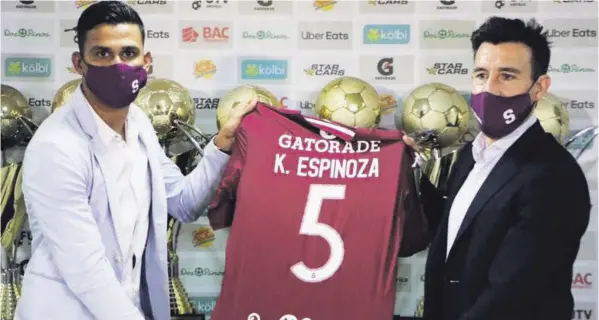  ?? CORTESÍa ?? El defensa Kevin Espinoza (izquierda), presentado por el gerente Ángel Catalina en Saprissa, es uno de los pocos refuerzos de los morados para el Apertura 2021. El campeón suma cuatro hasta ahora.