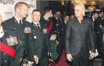  ?? TED RHODES/ CALGARY HERALD ?? Director and star Paul Gross is joined on the red carpet by Canadian Military members at Theatre Grand Junction for the opening of Hyena Road at the Calgary Film Festival Thursday evening. Gross trained with soldiers to prepare for his role in the...