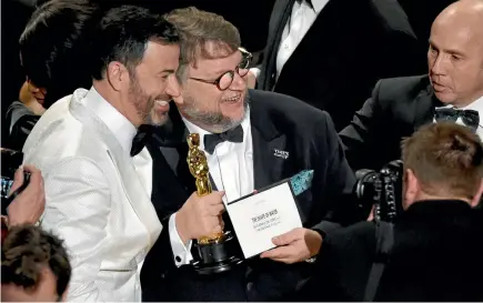  ?? PHOTO: AP ?? Jimmy Kimmel, left, congratula­tes Guillermo del Toro after del Toro won the award for best picture for The Shape of Water at the Oscars yesterday at the Dolby Theatre in Los Angeles.