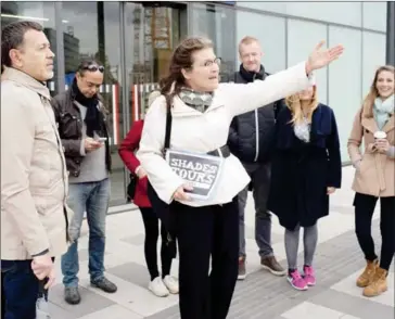  ?? JOE KLAMAR/AFP ?? Homeless tour guide Barbara (centre) talks to tourists near Hauptbahnh­of’s main train station during her ‘Shades Tours’ trip around the Austrian capital on October 30.