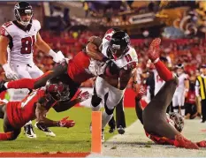  ?? (Reuters) ?? TAMPA BAY BUCCANEERS defenders bring down Atlanta Falcons receiver Julio Jones (11) just short of the goal-line during the first half of the Falcons’ 27-24 road victory over the Bucs on Monday night, a result that kept Atlanta in the playoff race with...