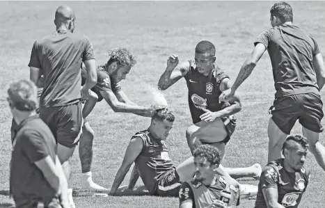  ?? (AP PHOTO/ANDRE PENNER) ?? BIRTHDAY FUN. Brazil's soccer players Neymar, left, and Gabriel Jesus, throw flour and eggs on the head of teammate Philippe Coutinho, to jokingly celebrate Coutinho's birthday, during a training session in Sochi, Russia, Tuesday, June 12, 2018. Brazil...