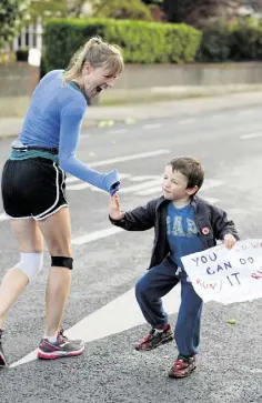  ??  ?? COOL RUNNING: Oliver Geoghan from Clonskeagh offers a ‘high five’ to a runner in last year’s Dublin City Marathon